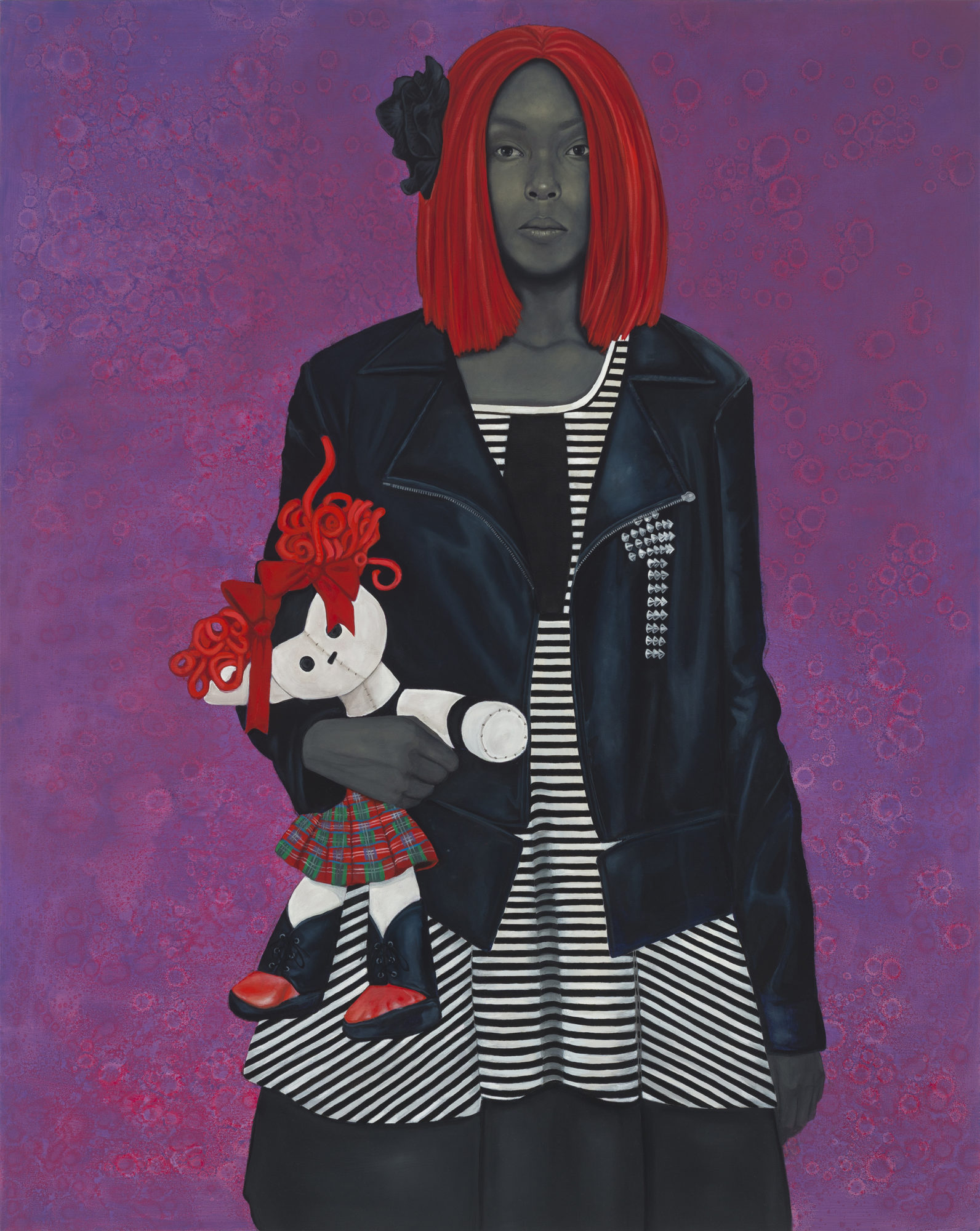 A woman with red hair holding a rag doll in front of a textured, colored background