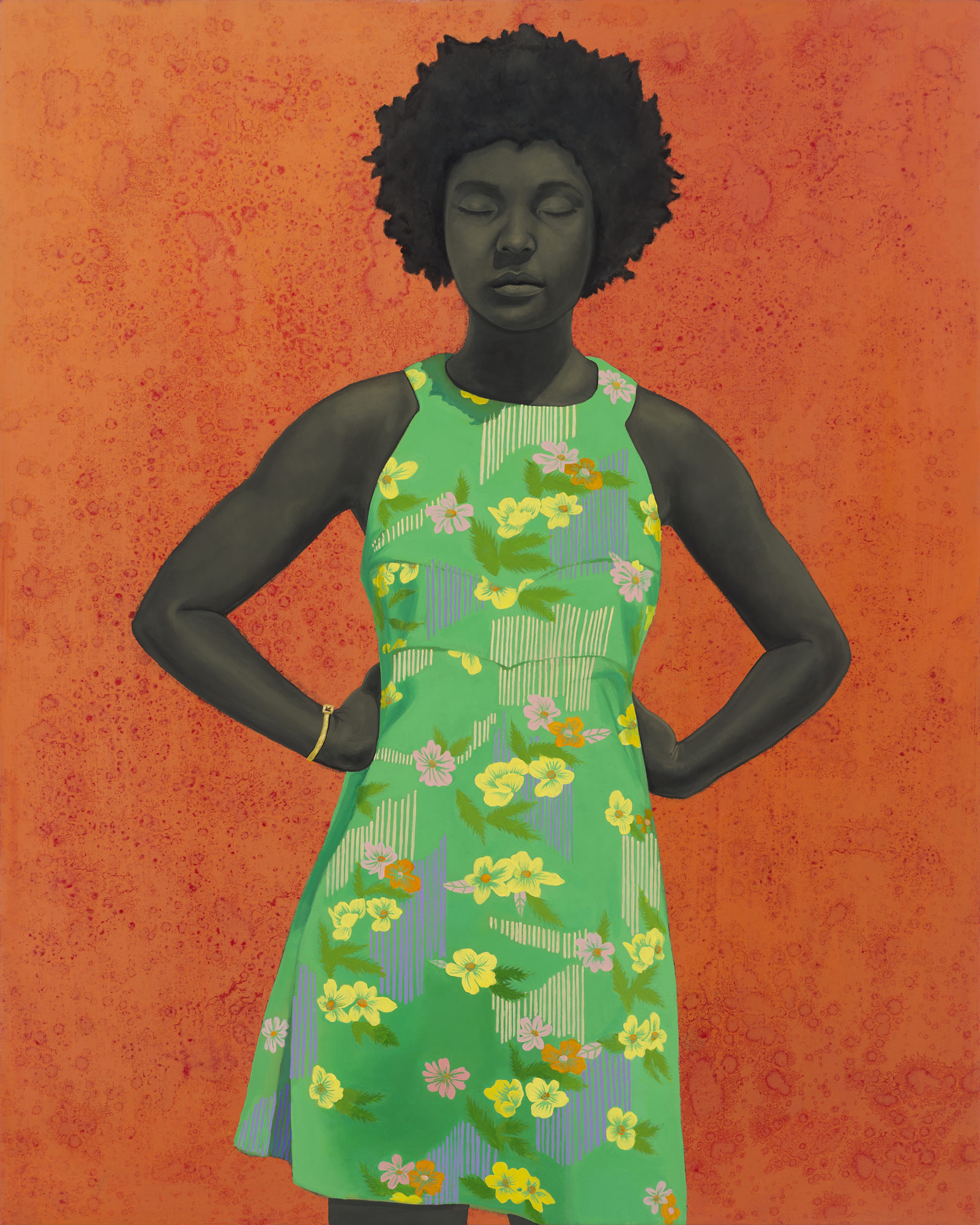 A woman in a floral green dress poses in front of a deep orange, textured background