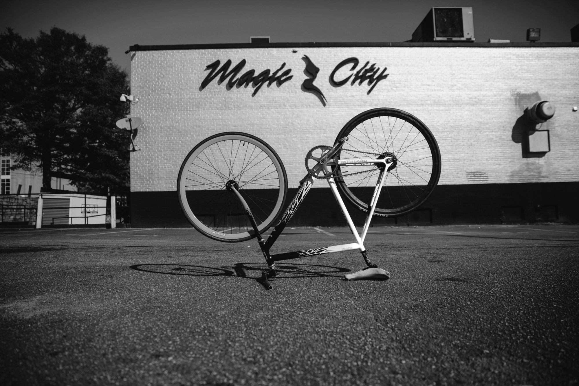 A black and white photo of an upside down bike in front of Magic City