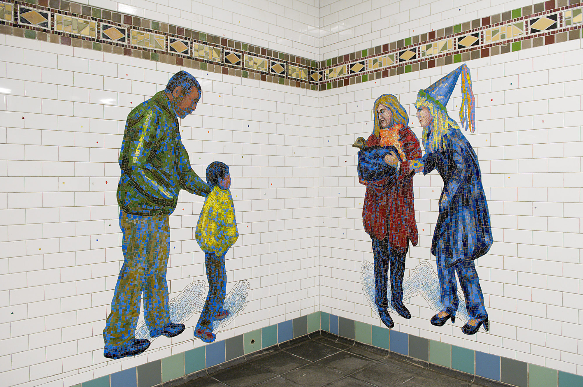A mosaic at the corner of a subway station of three adults tending to a child