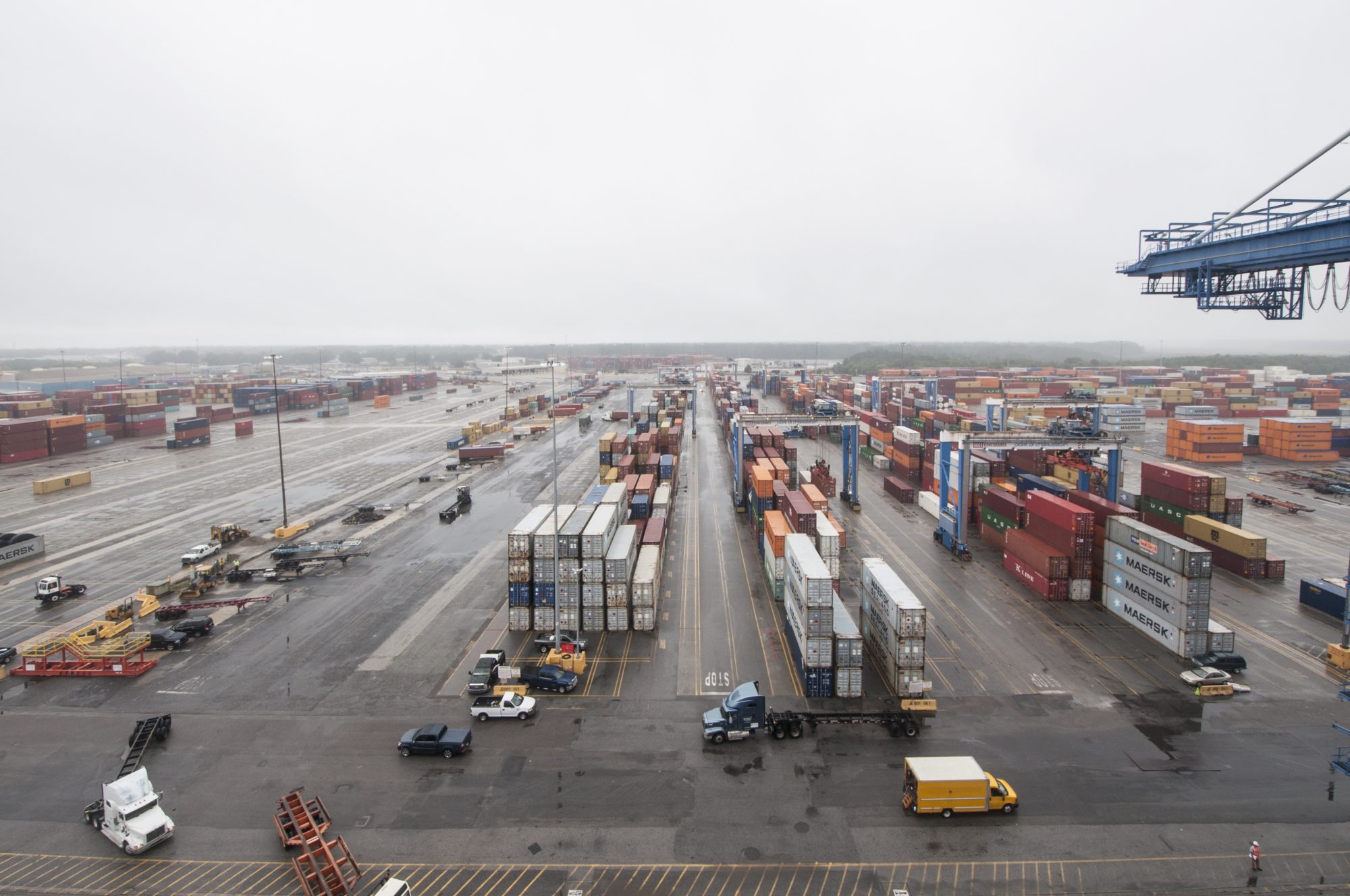 large number of shipping containers in various colors stacked and arranged in definite rows in a shipyard