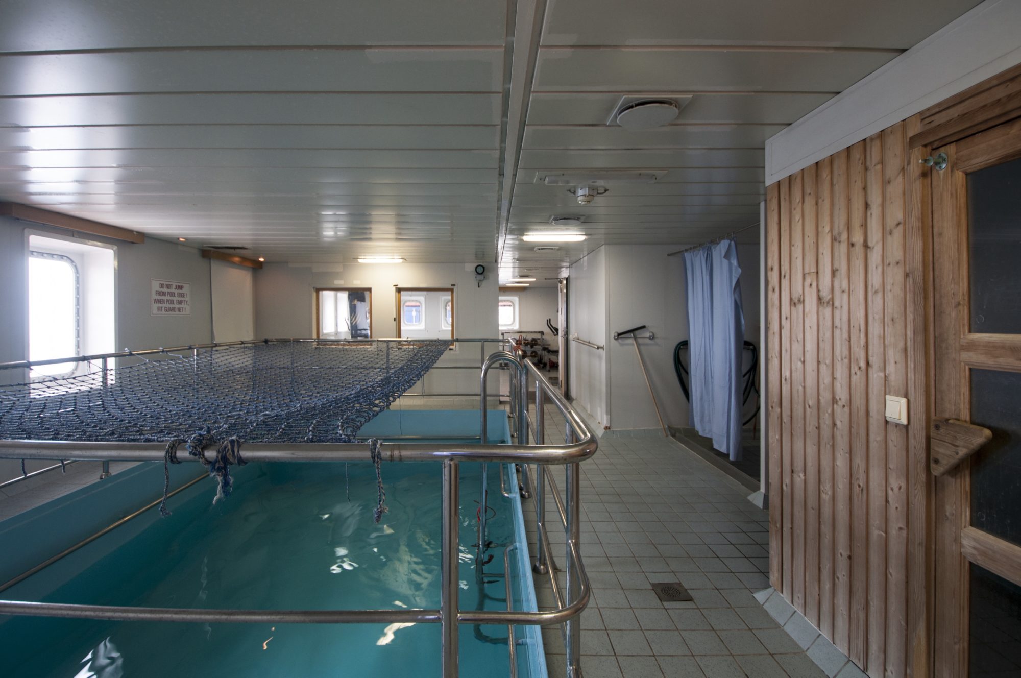 indoor pool of cargo ship pictured, blue netted covering a quarter of the way open