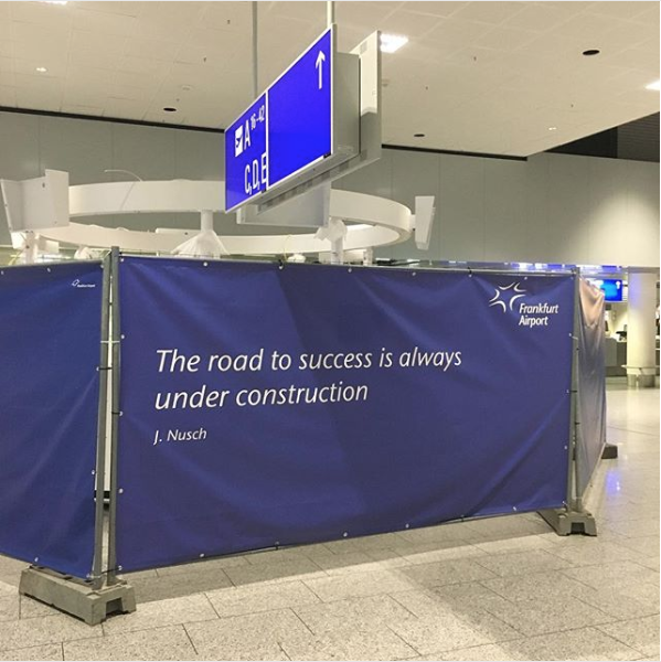 a cloth construction border in an airport hallway with the quote 