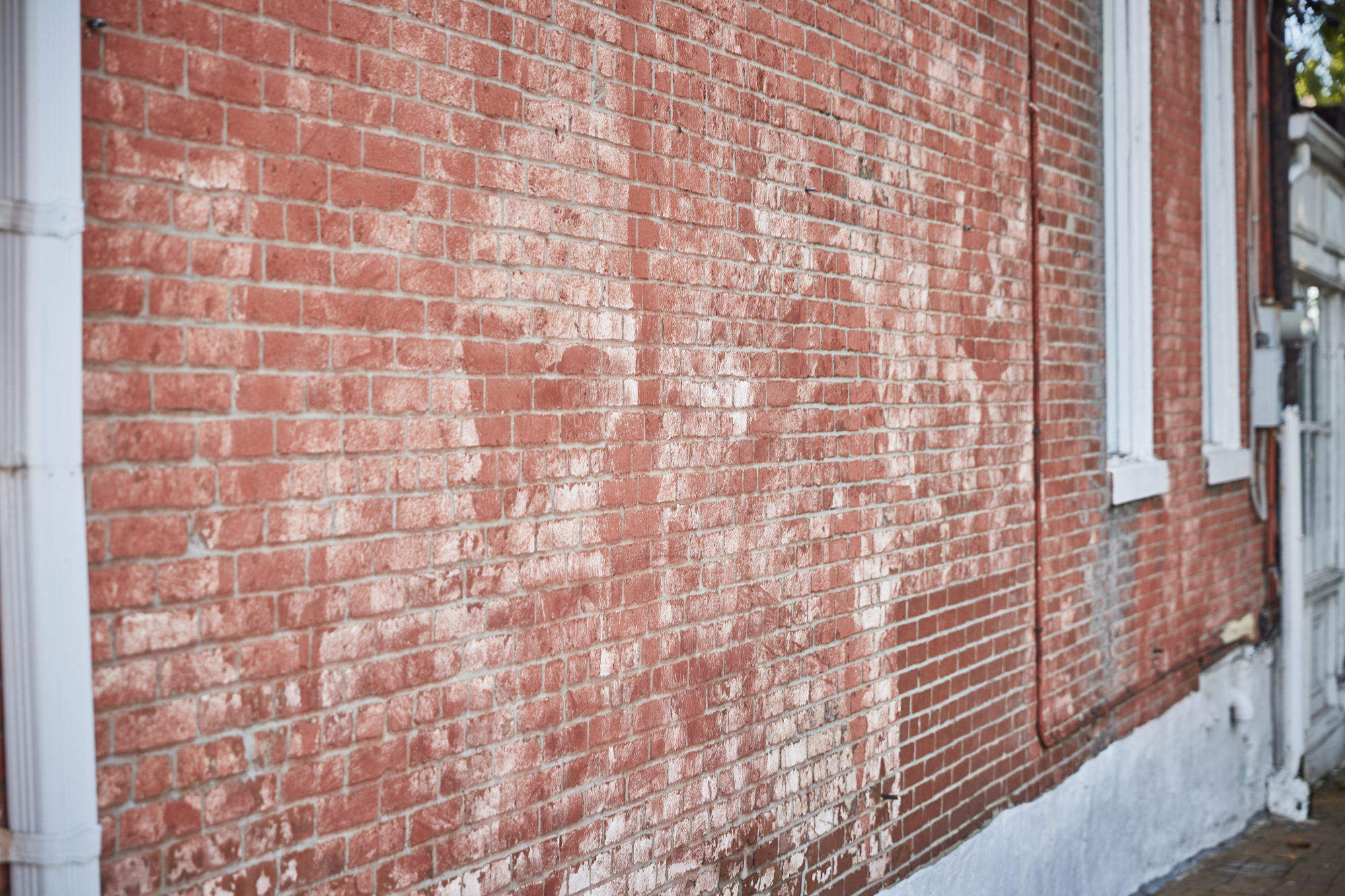 a brick wall with interesting white paint stains