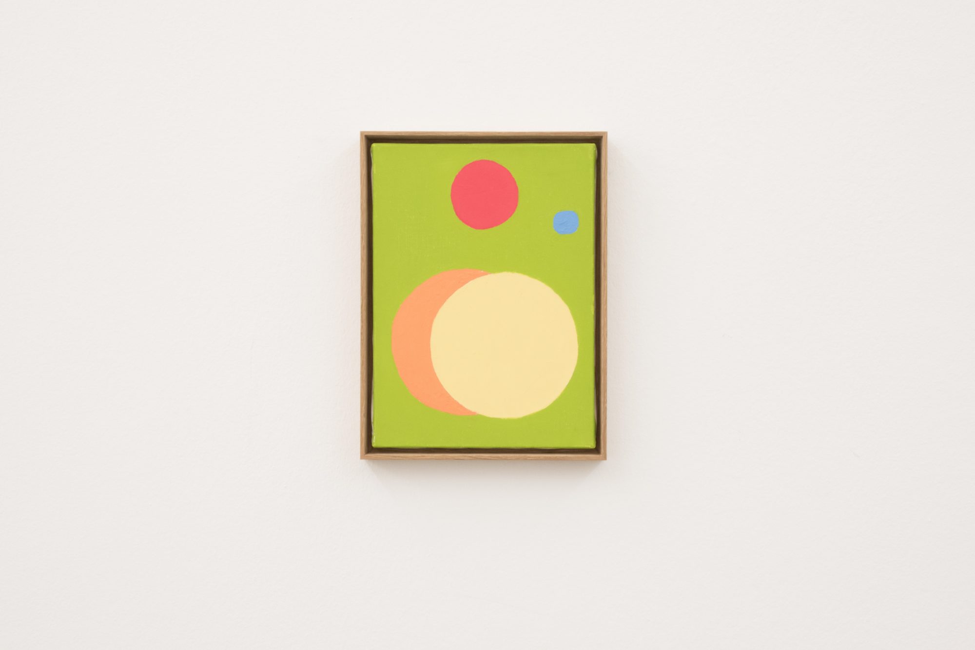 An abstract oil painting comprised of circles against a pear-green background.