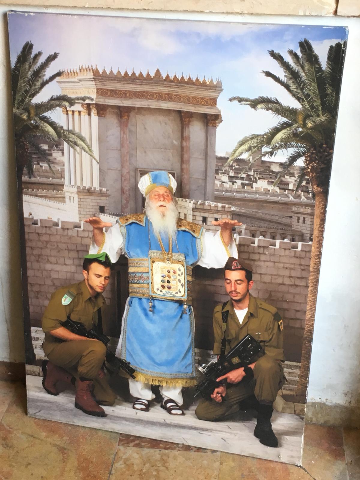 A poster of a High Priest of Israel with his hands hovering over two soldiers.