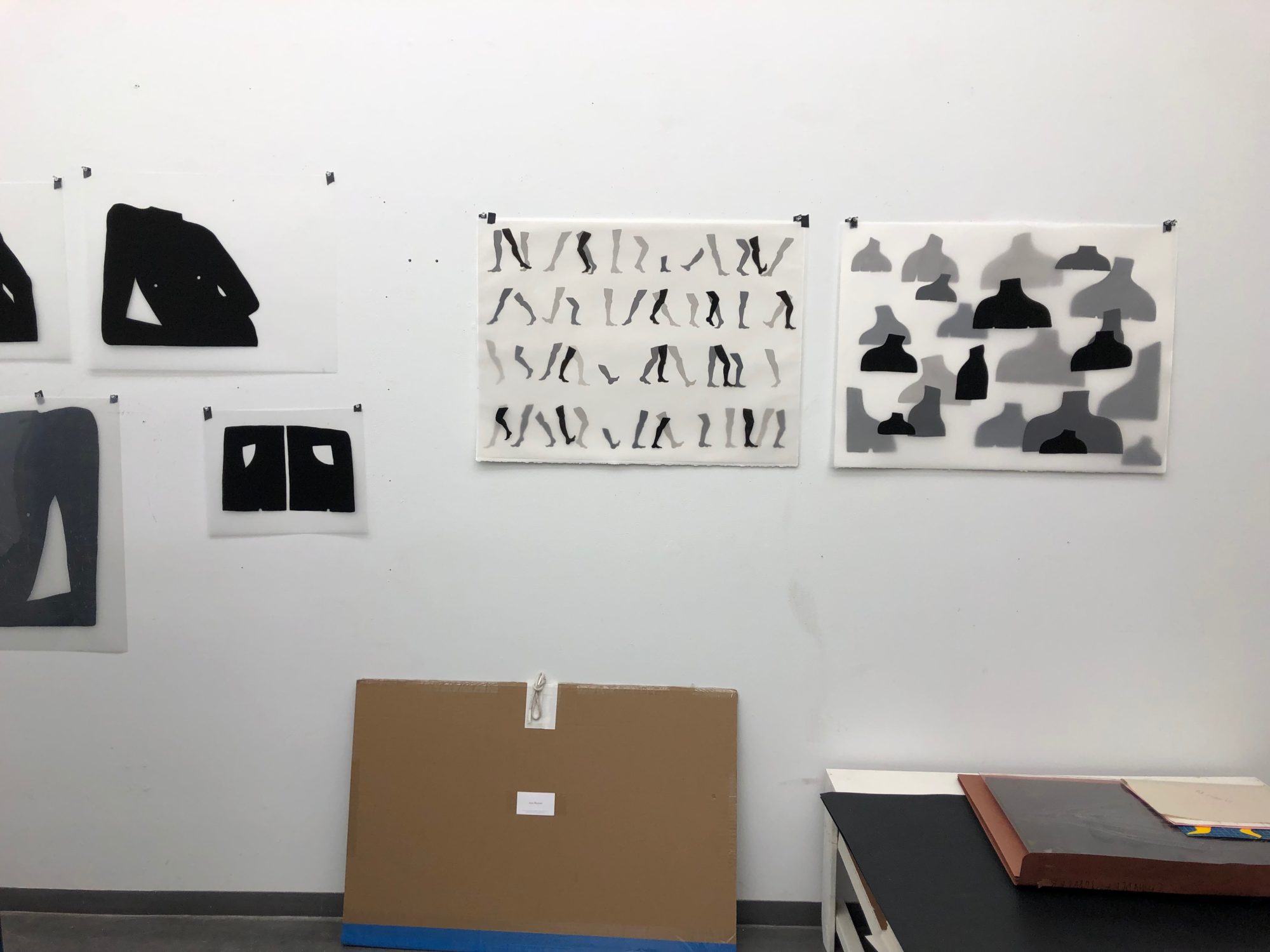 Black and white prints hanging on a wall in a printmaking studio