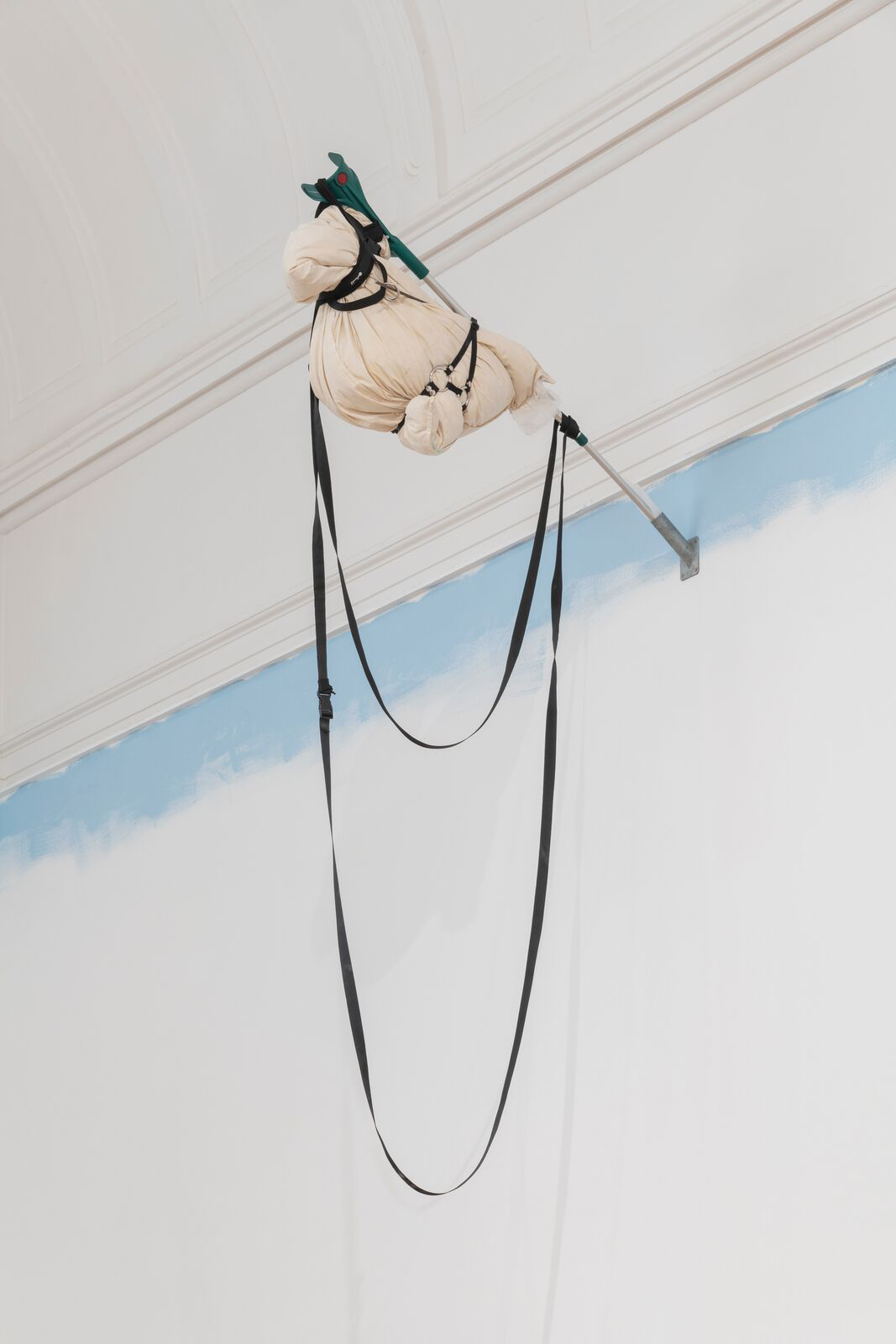 lumps of cloth attached to a pole form the wall with black rope