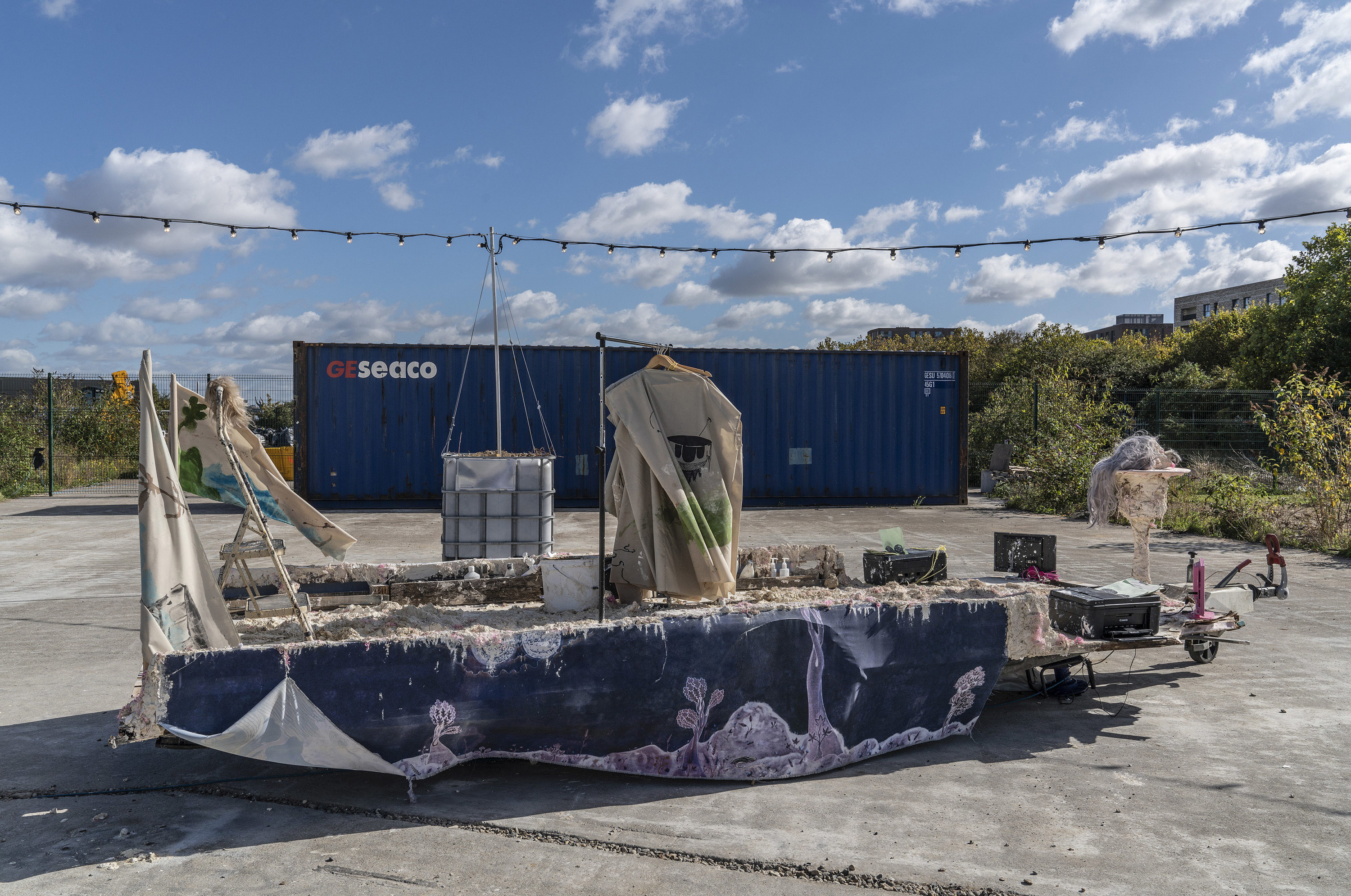 navy platform on wheels with objects like a rack of hangers