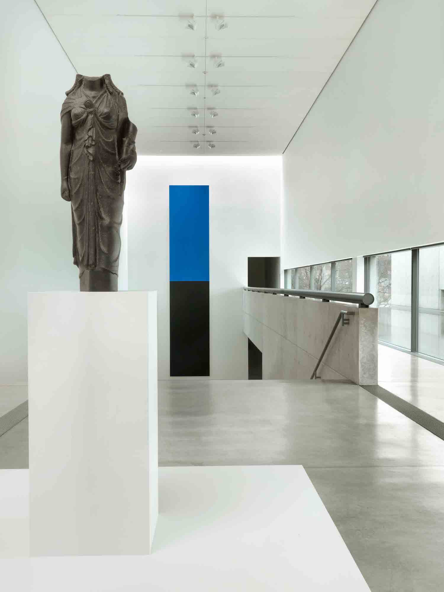 photo of a headless statue in a white gallery.