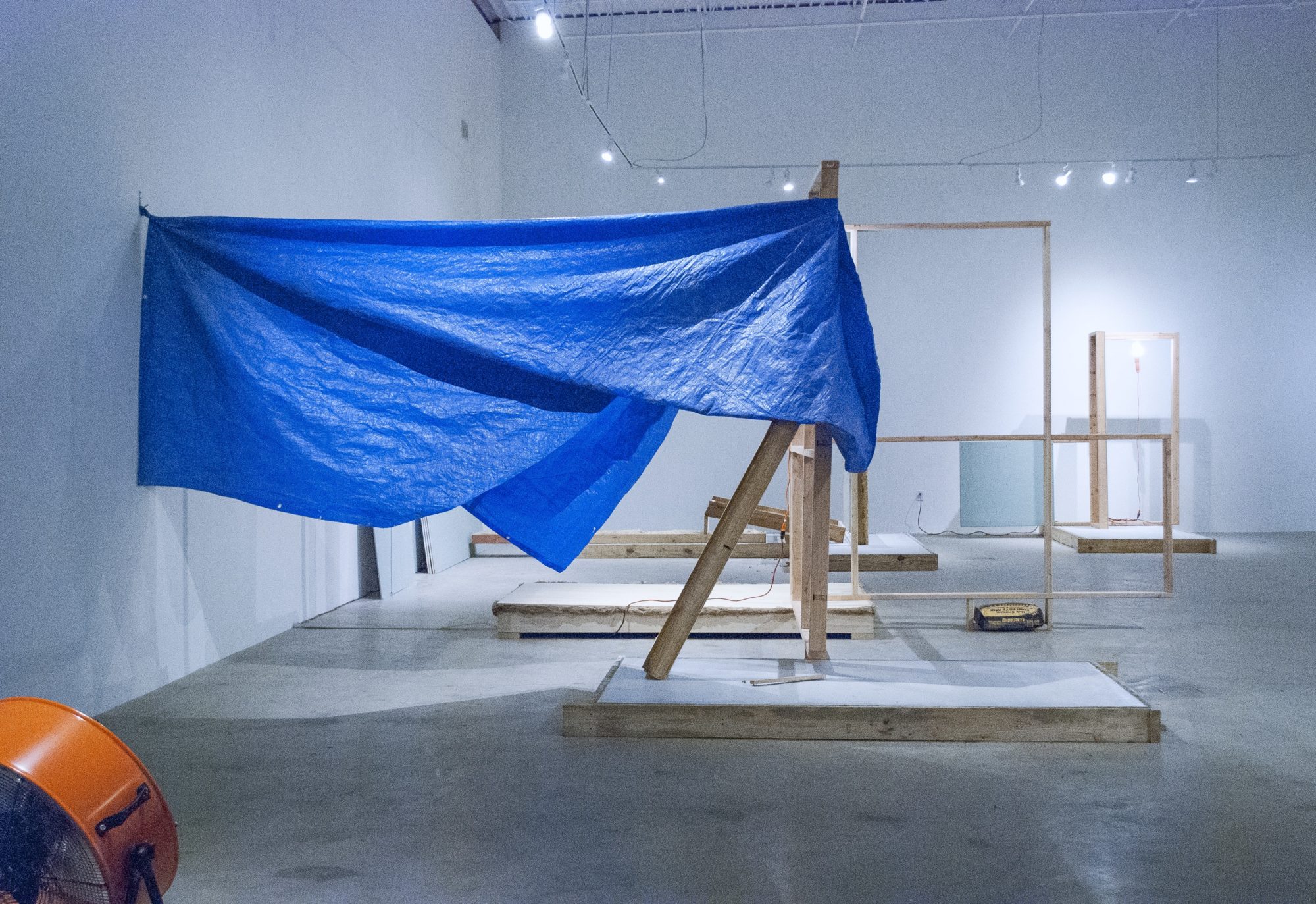construction site with blue tarp and wood blocks staged in museum space