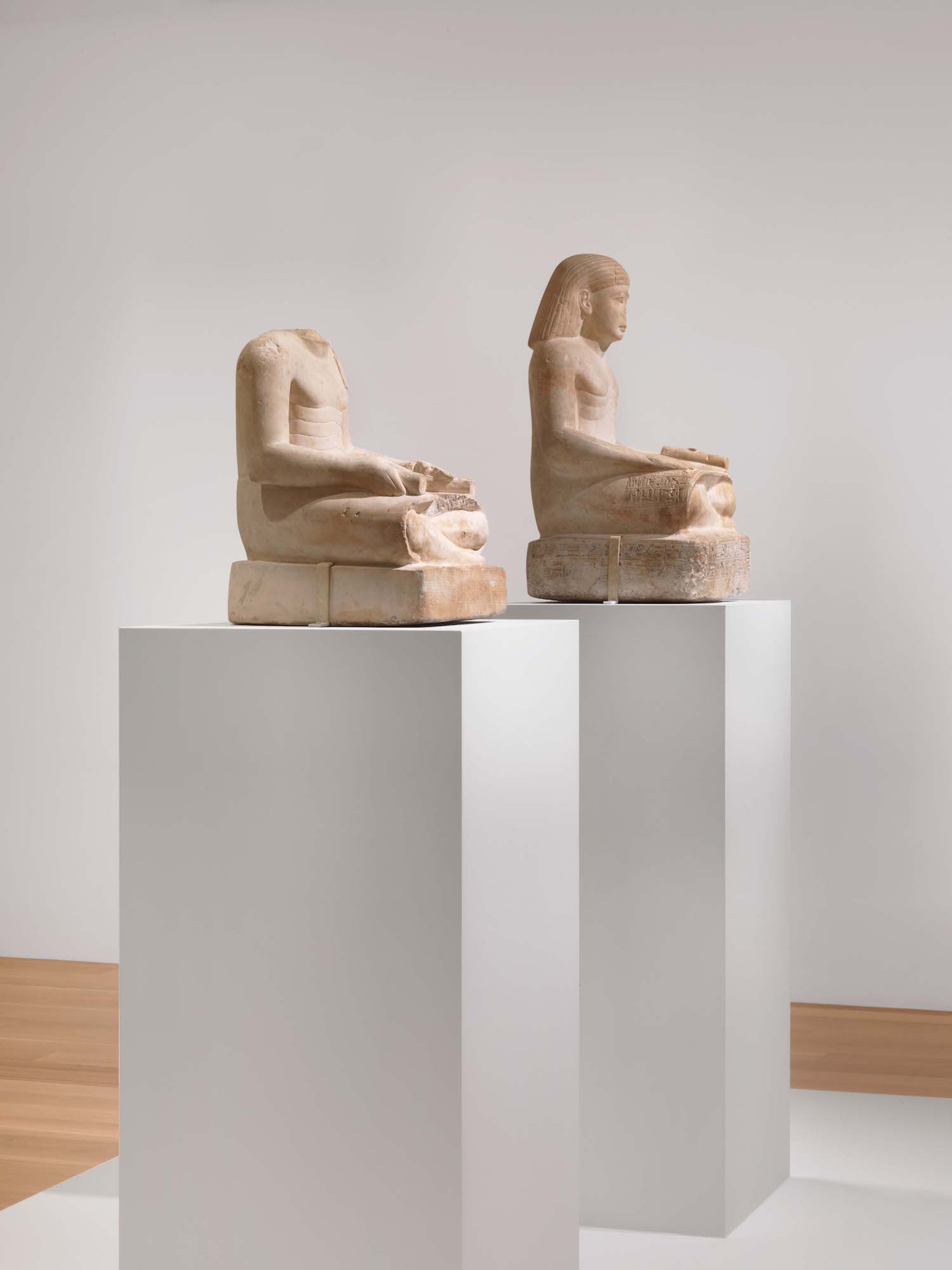 Photo of two statues in an ancient Egyptian art exhibition.