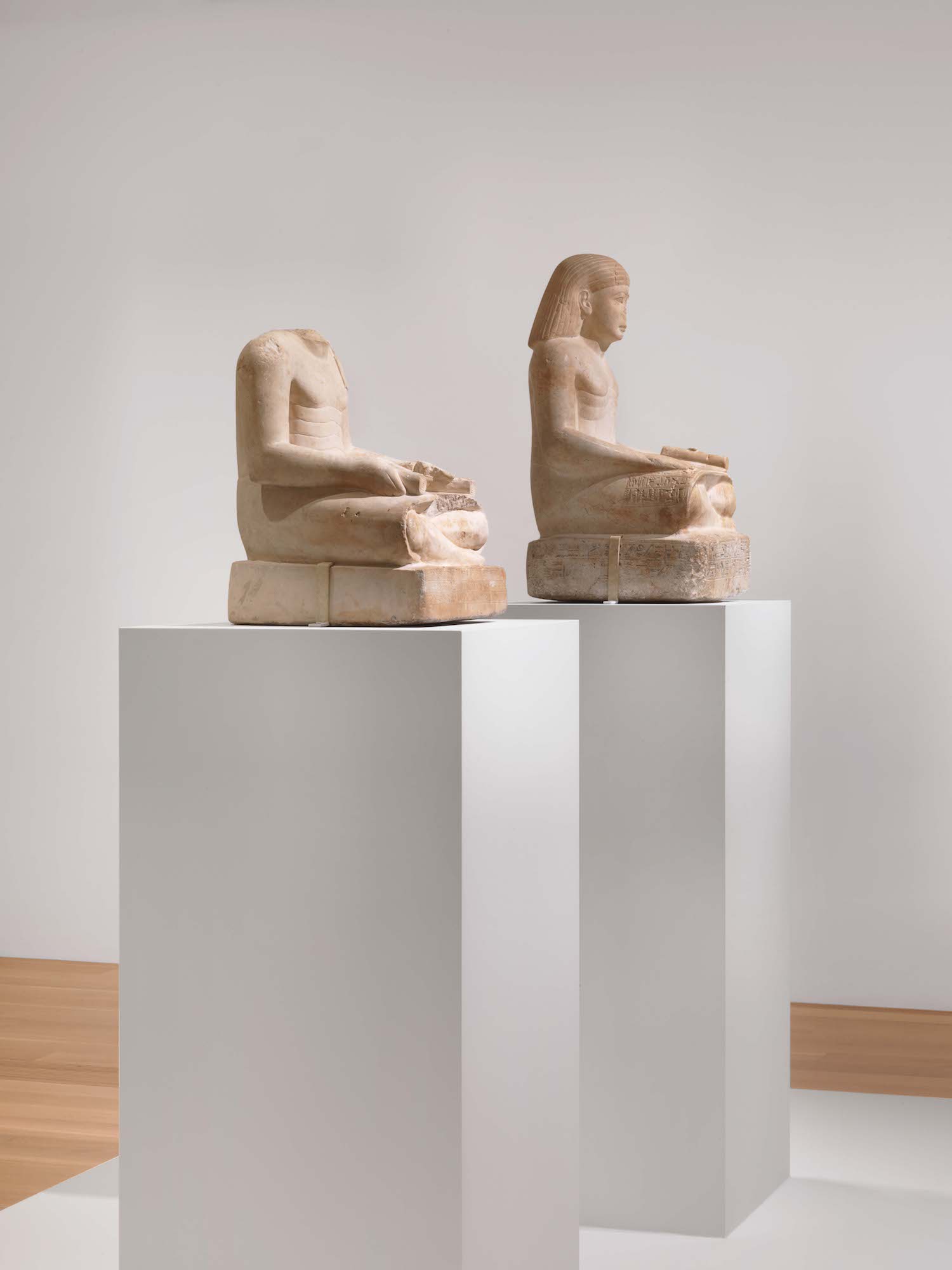 Photo of two statues in an ancient Egyptian art exhibition.