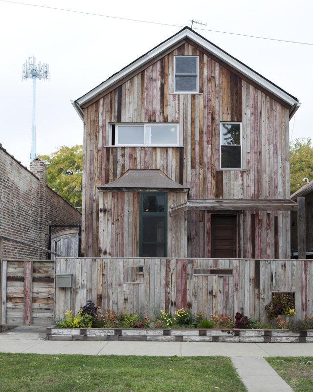 Shot of outside of Theaster Gates' home; the outside is completely vertical wooden slats of varying colors and wear