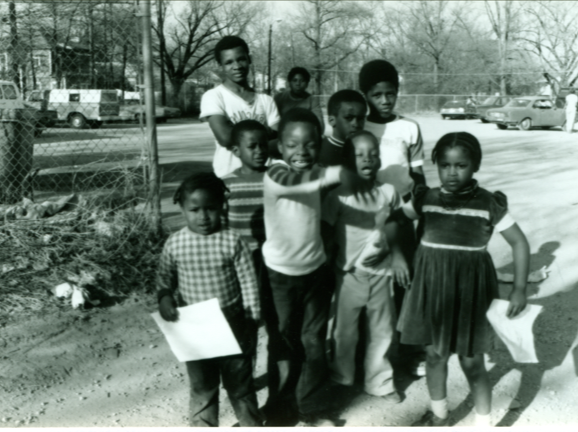 A black-and-white photo of several young children standing together.