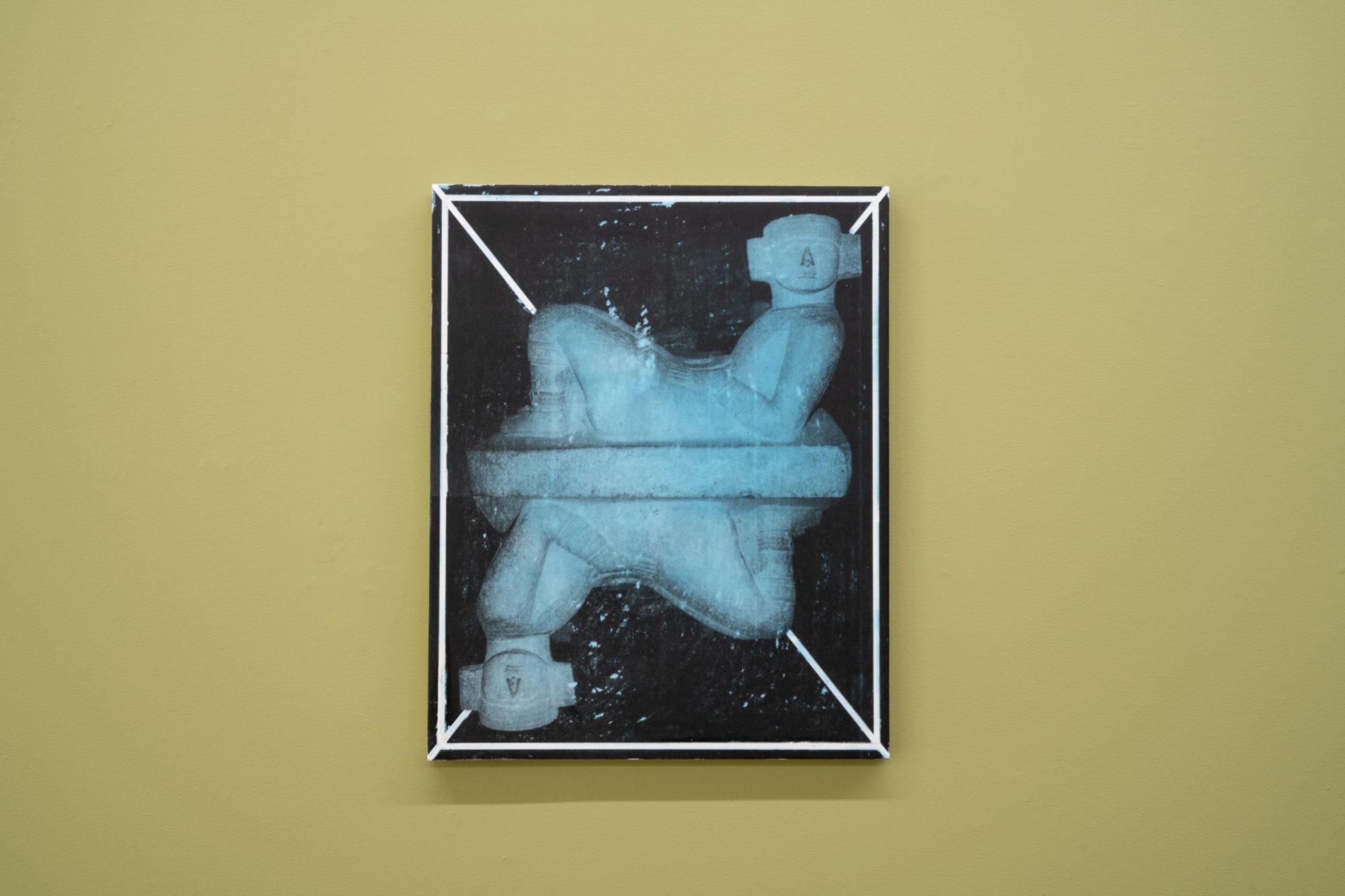 An image copied onto a wax panel which shows a sculpture that is reflected below, creating two images of the sculpture.