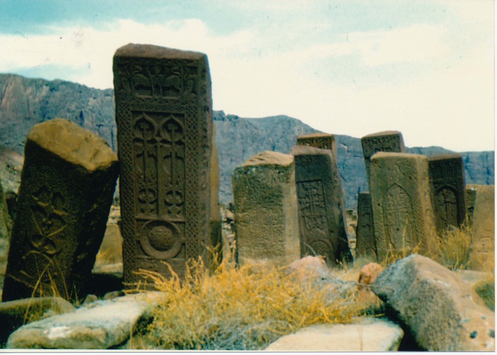 Photograph of several monuments/boulders known as Khachkars, in the Julfa cemetery carved with Christian symbols. Some are leaning over, as if on unstable ground.