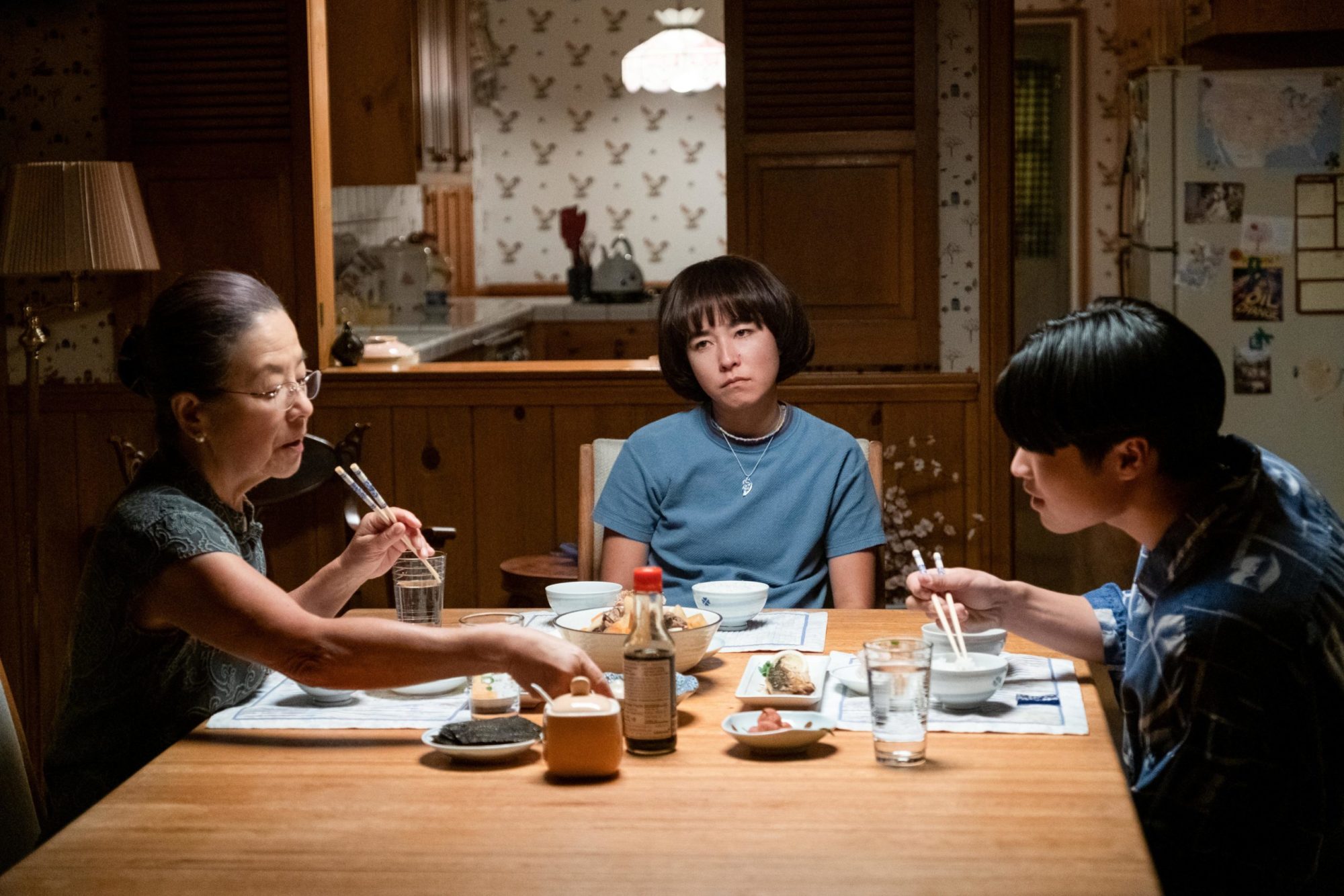 Actor Maya Erskin sits at the dinner table with her mother and brother in a scene from the TV show 