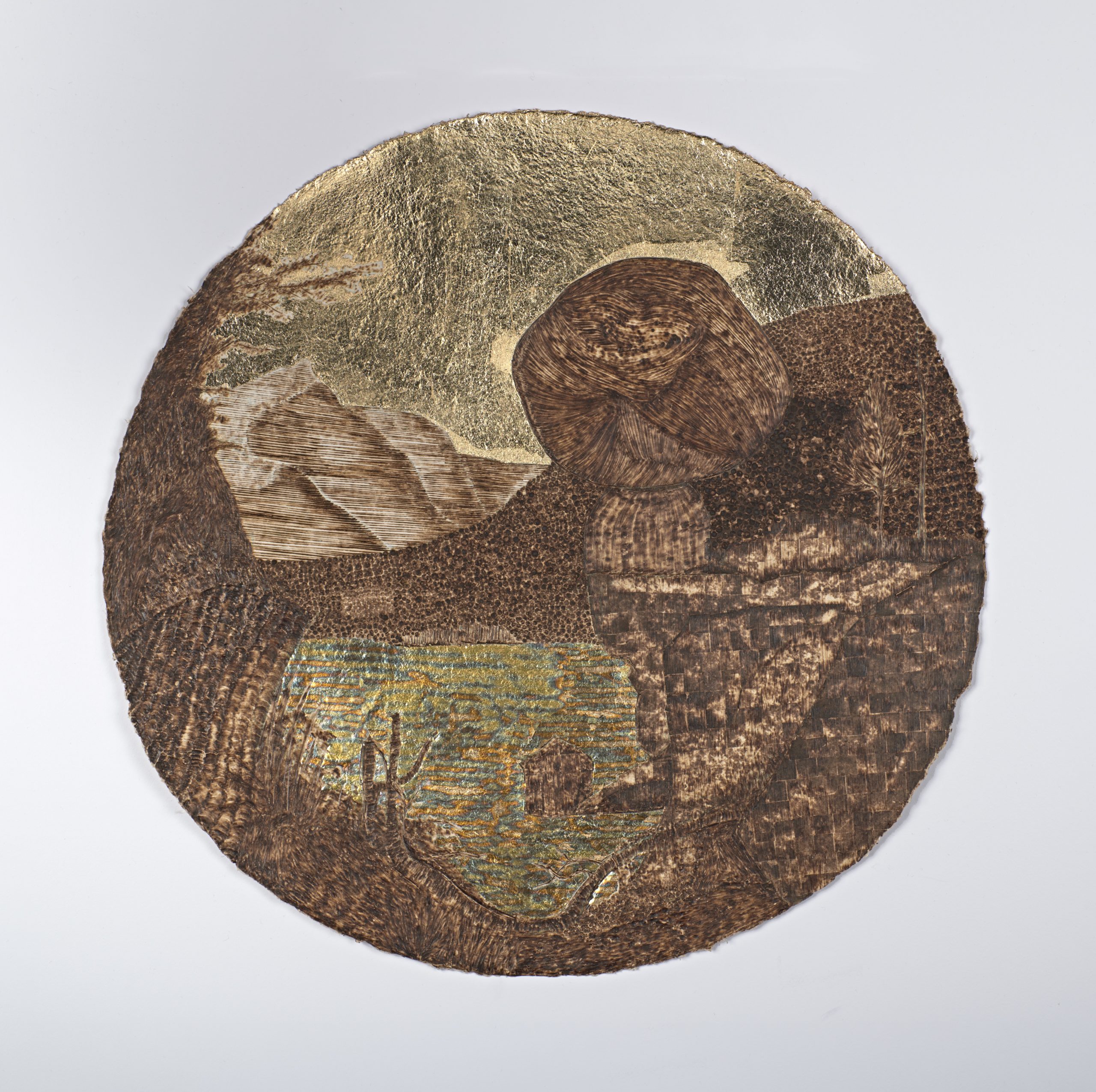 circular piece of paper displaying rocks and trees with a pond.