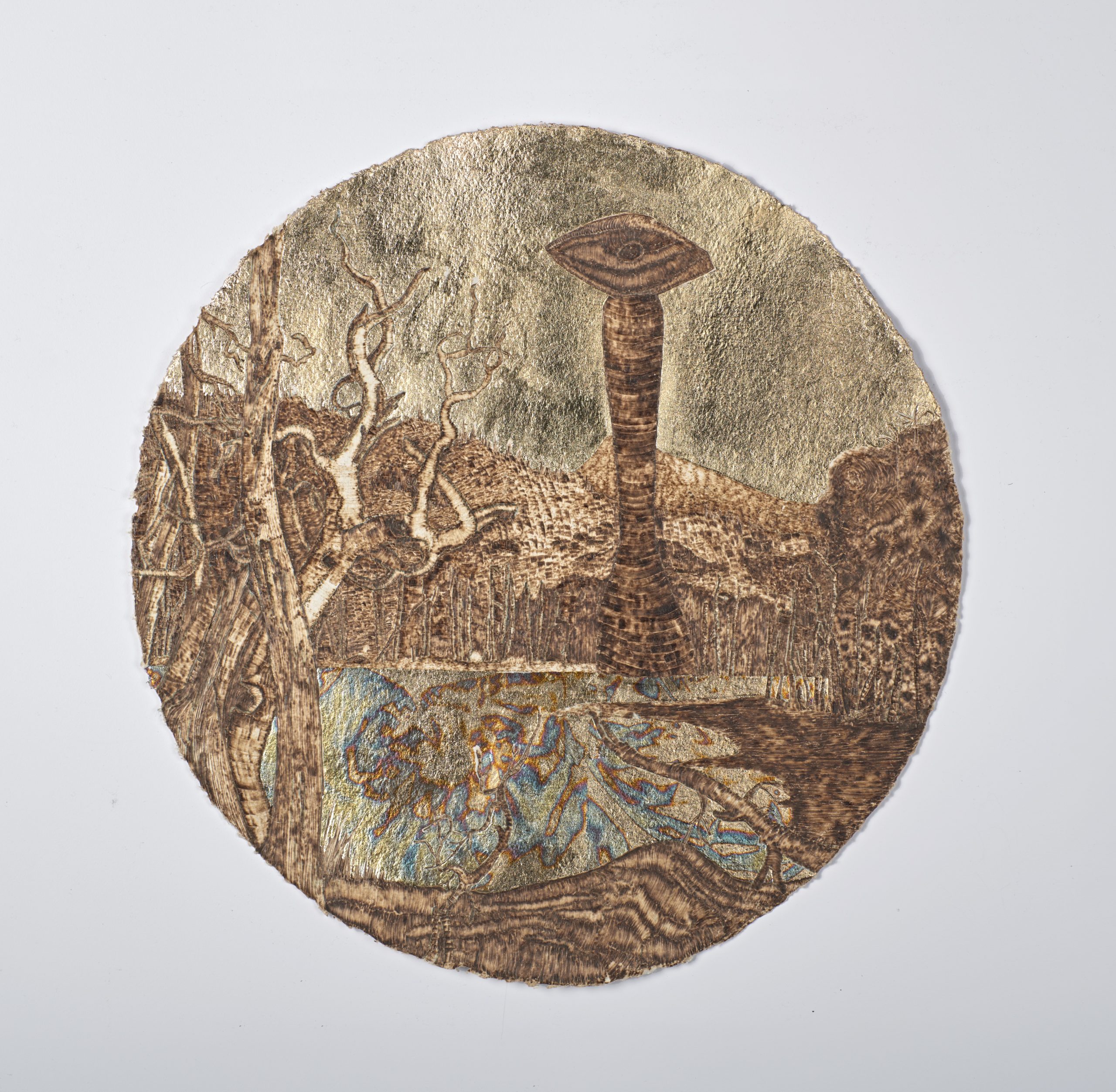 Circular piece of paper displaying a pond surrounded by trees and a rock formation.