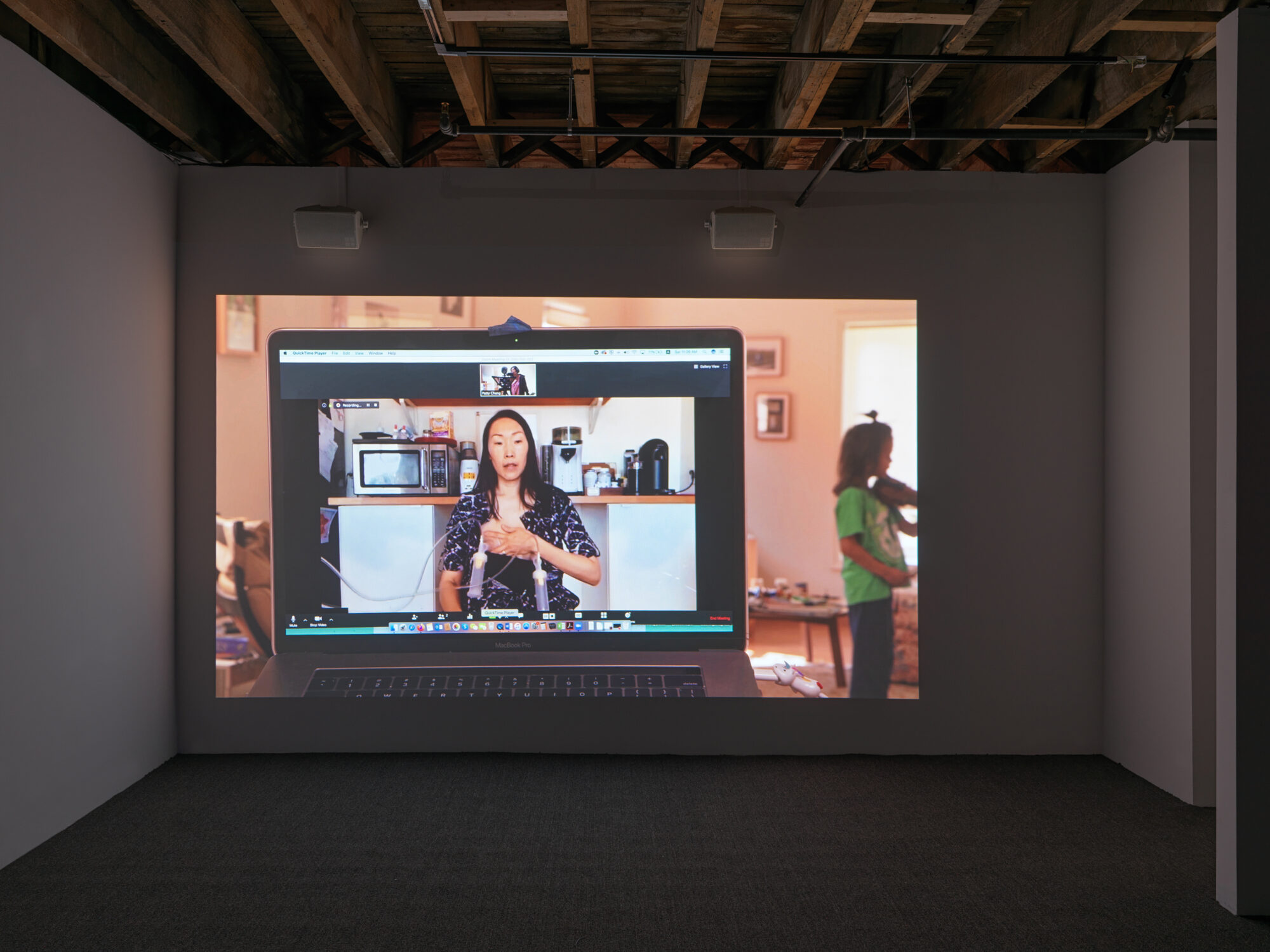 Projection of a woman breastpumping on a video chat on a laptop