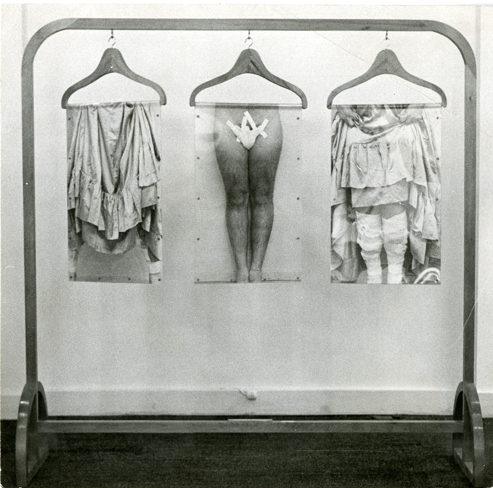 A wooden clothes rack with three hangers display a triptych of photo-based collages of the lower body.
