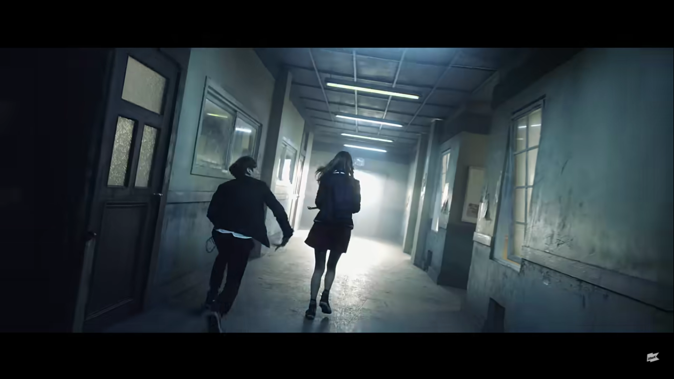 A member of BTS chases a school girl down a school hallway.