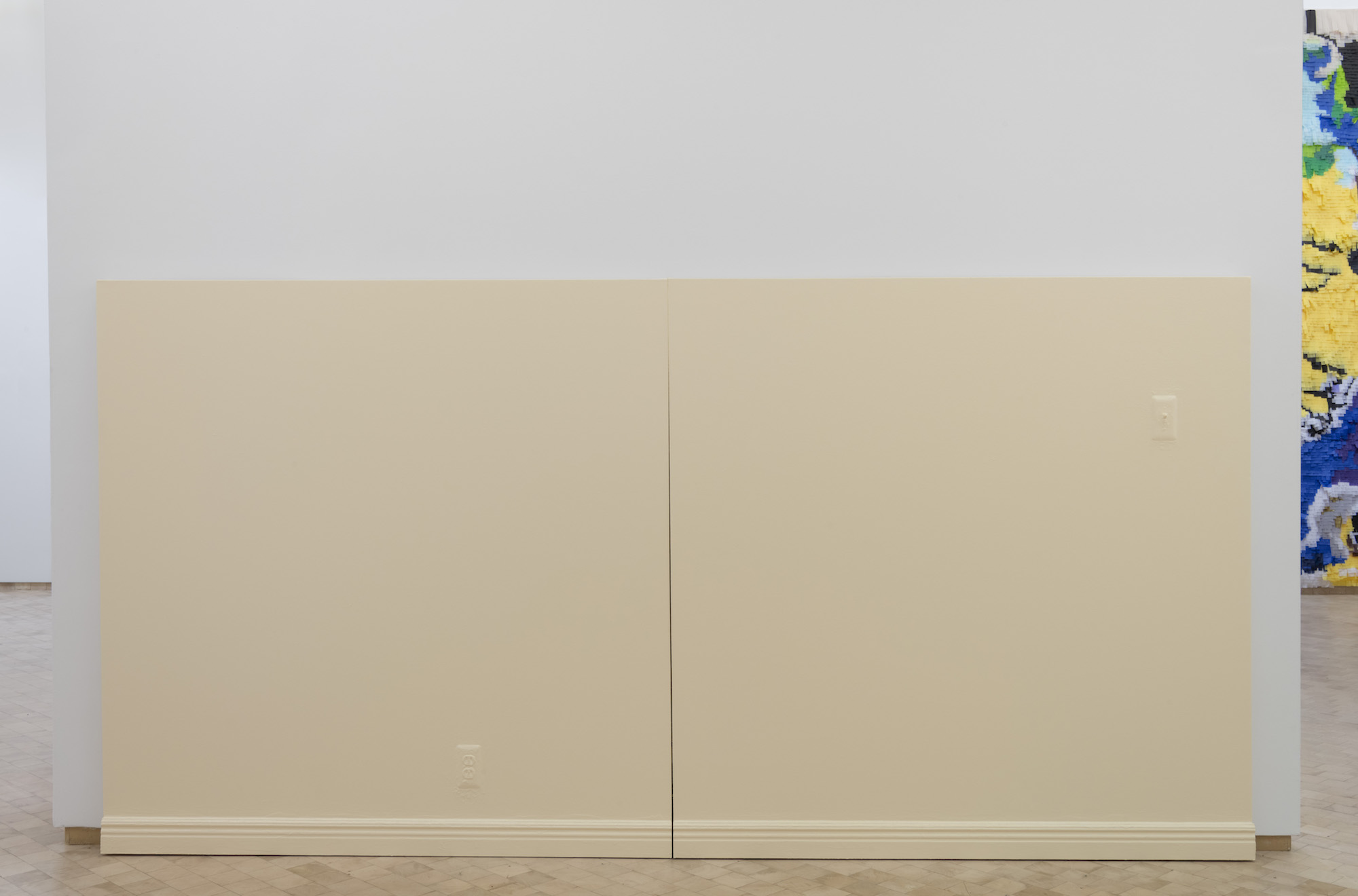 Art Installation presented against white gallery walls. A large piece of electrical wood is displayed against white gallery walls.