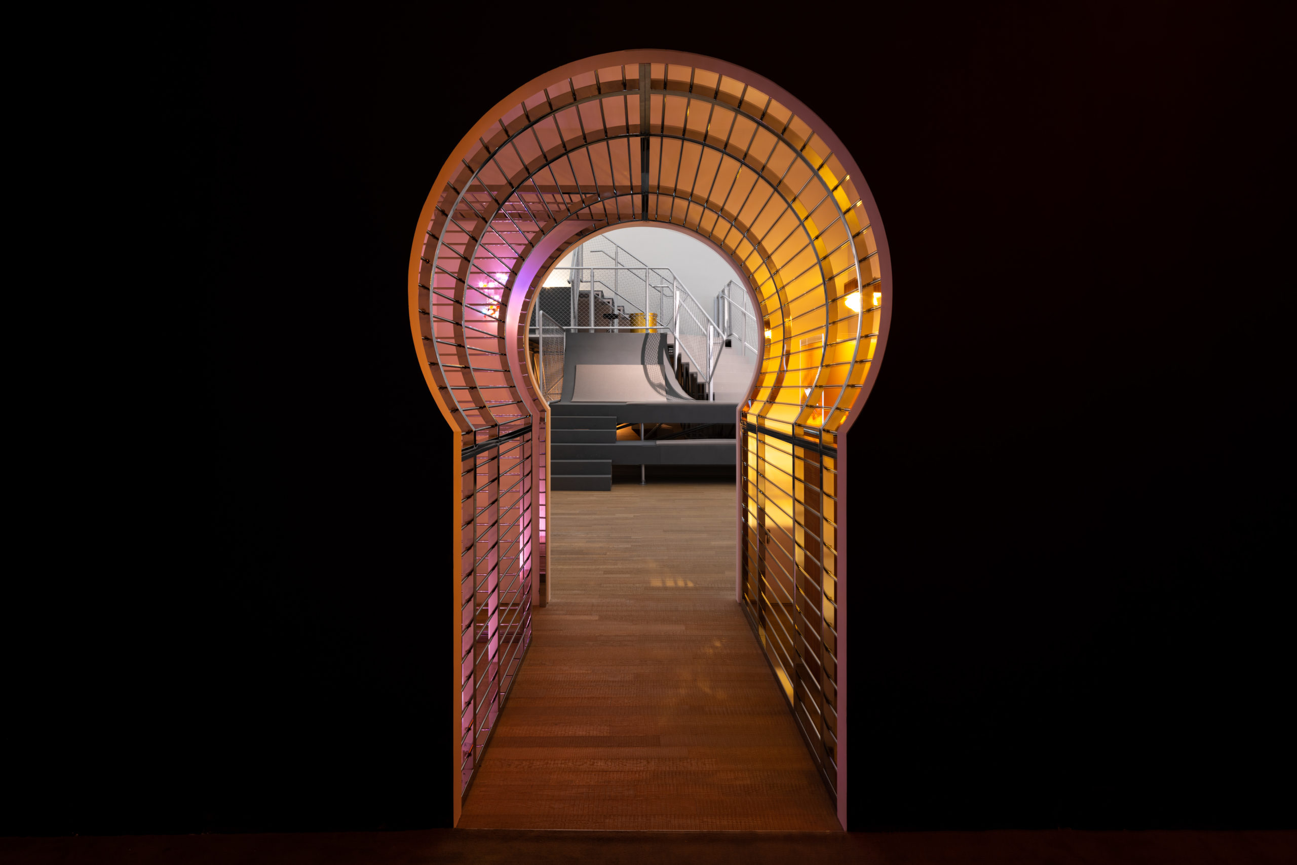 A key shaped hallway leading to a hall with a golden drum set and gray stairs on the center. Image provided by courtesy of the artist and Tai Kwun Contemporary