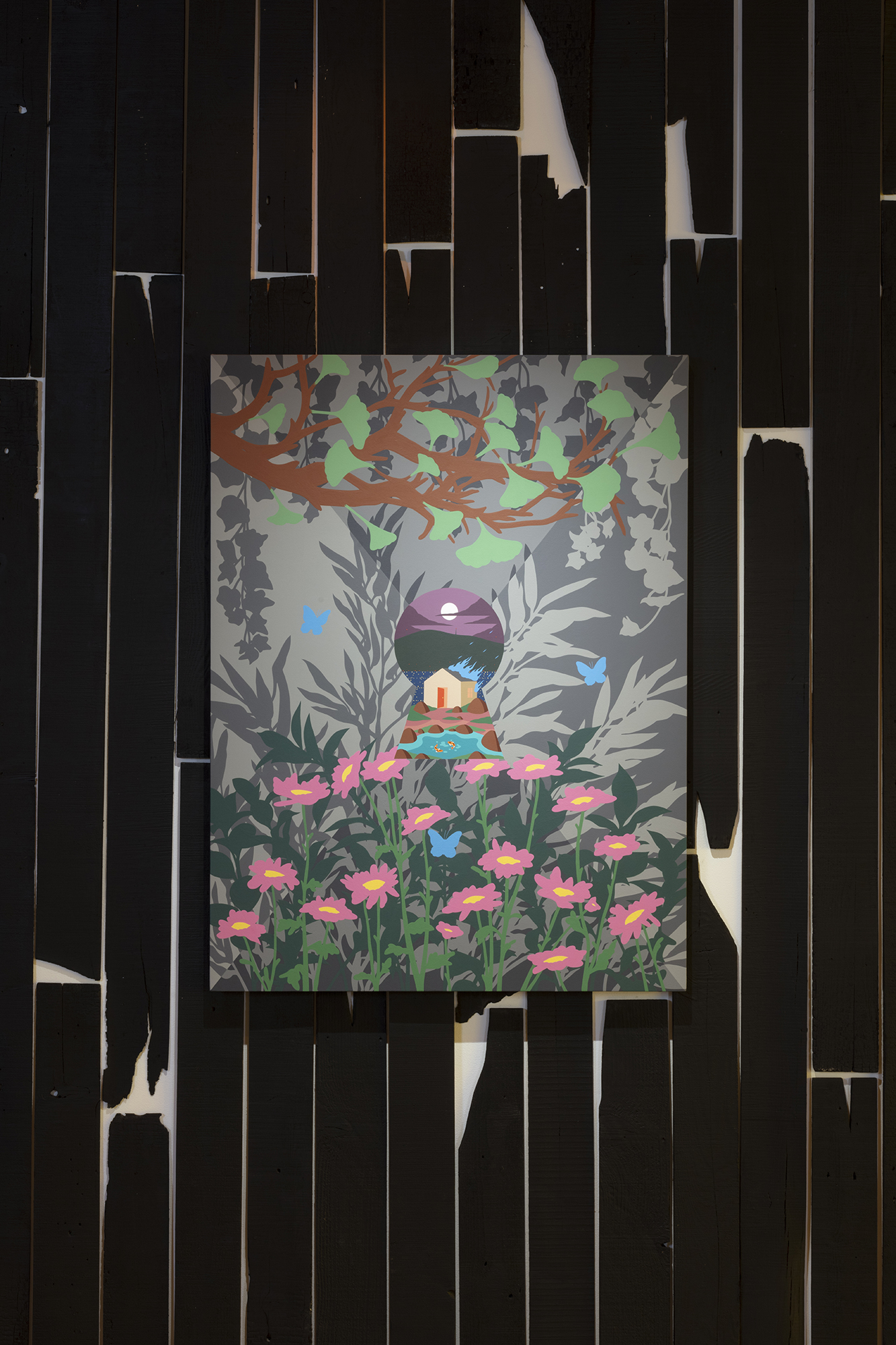 Against a black backdrop of burnt wood hangs Greg Ito's painting of pink flowers and disney-esque landscape
