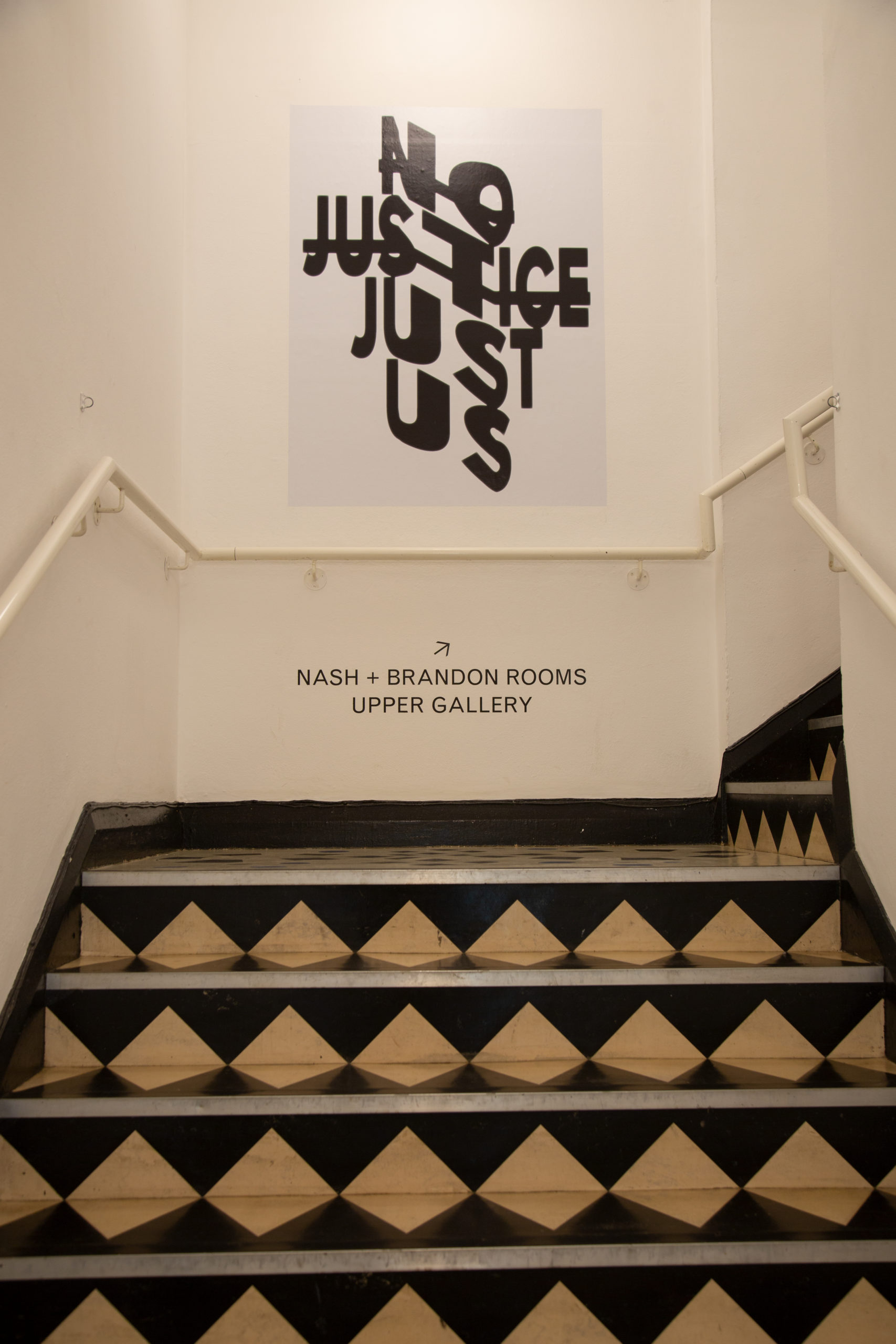 A set of stairs, and at the top a wall with a white poster reading 