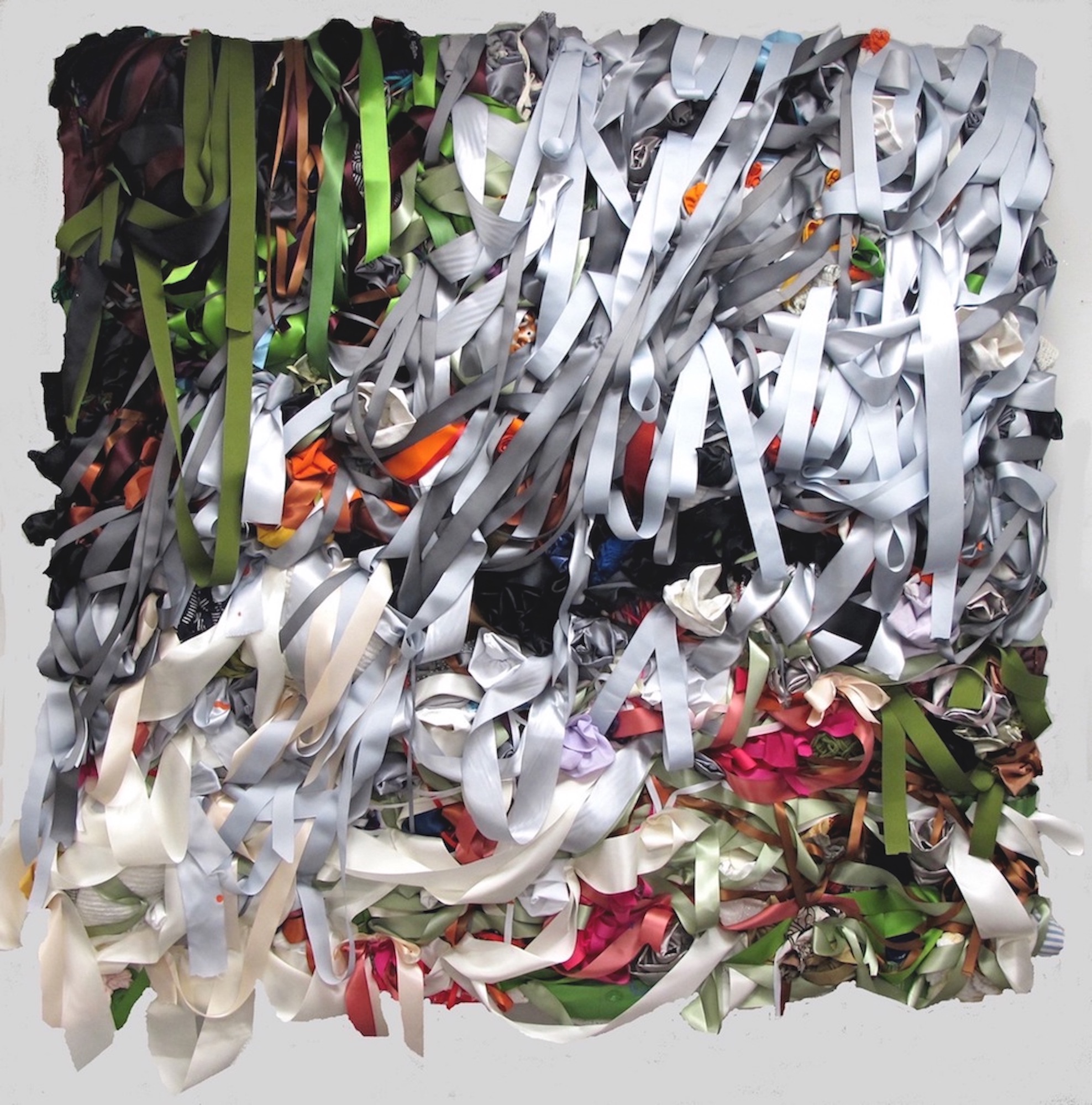A mass of silver, green, red, and black ribbons together in a twisted mass