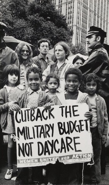 Black and white photo from the 1970's of a group of children at a protest, holding a sign that reads, 