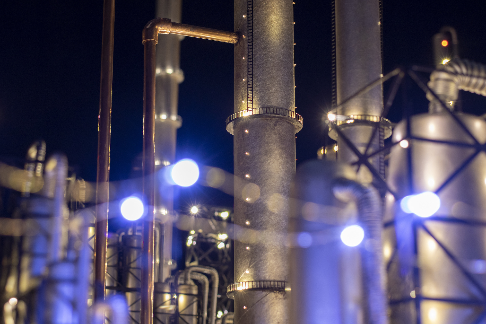 A close up of what look like structures within an oil refinery, long tubes extending up and down, but upon closer inspection these are miniatures simulating the actual structures.