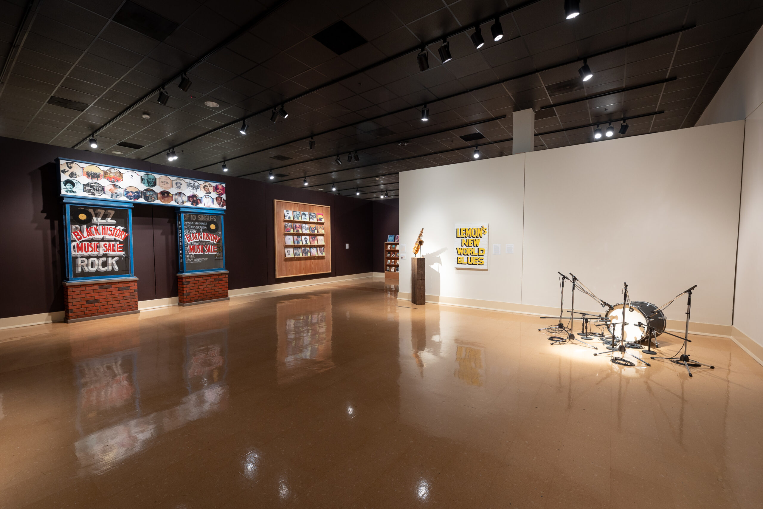 Installation view of pride records with a store front and drums and microphone