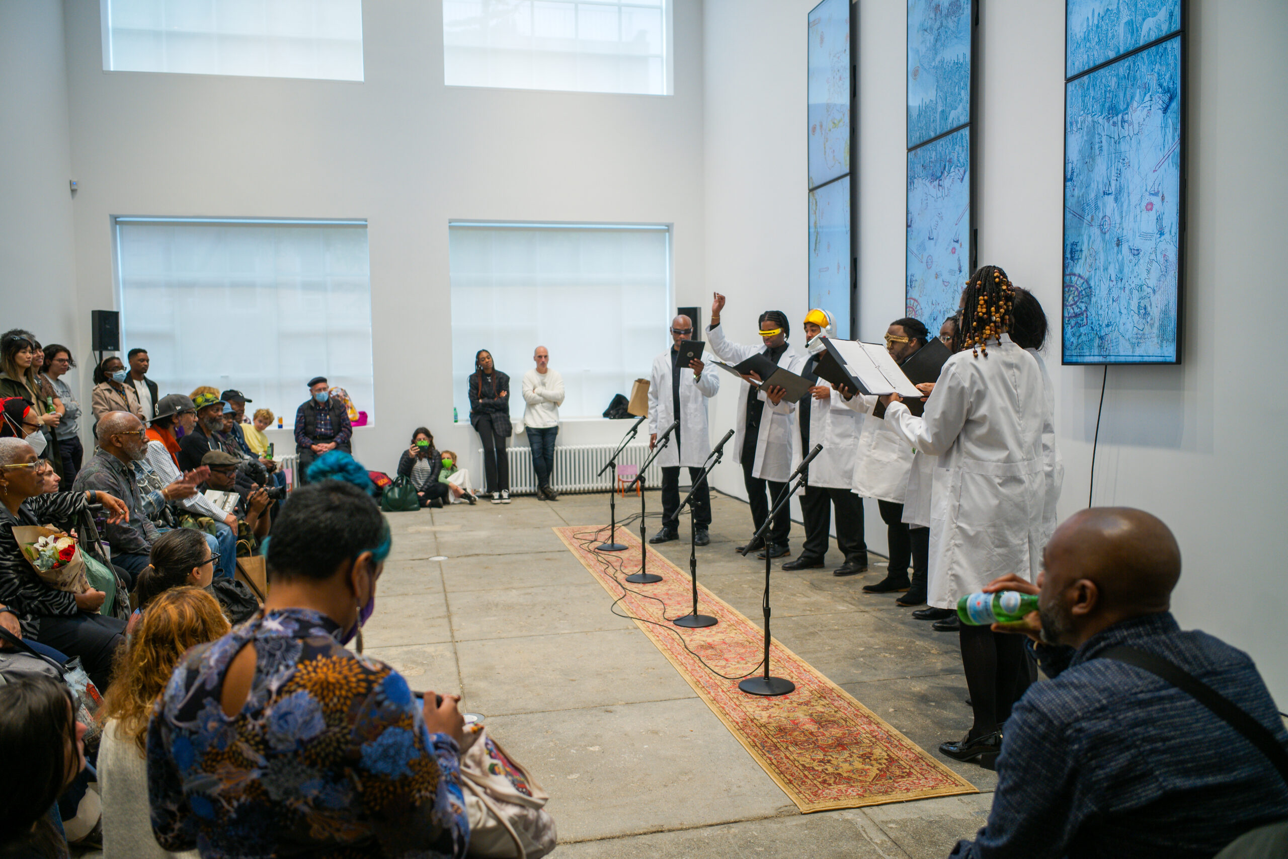 An audience watches performers dressed in white preform a song