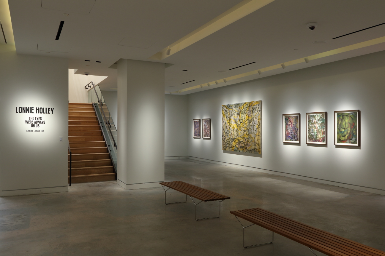 A room, dimly lit, wooden benches in the middle, with wall text reading 