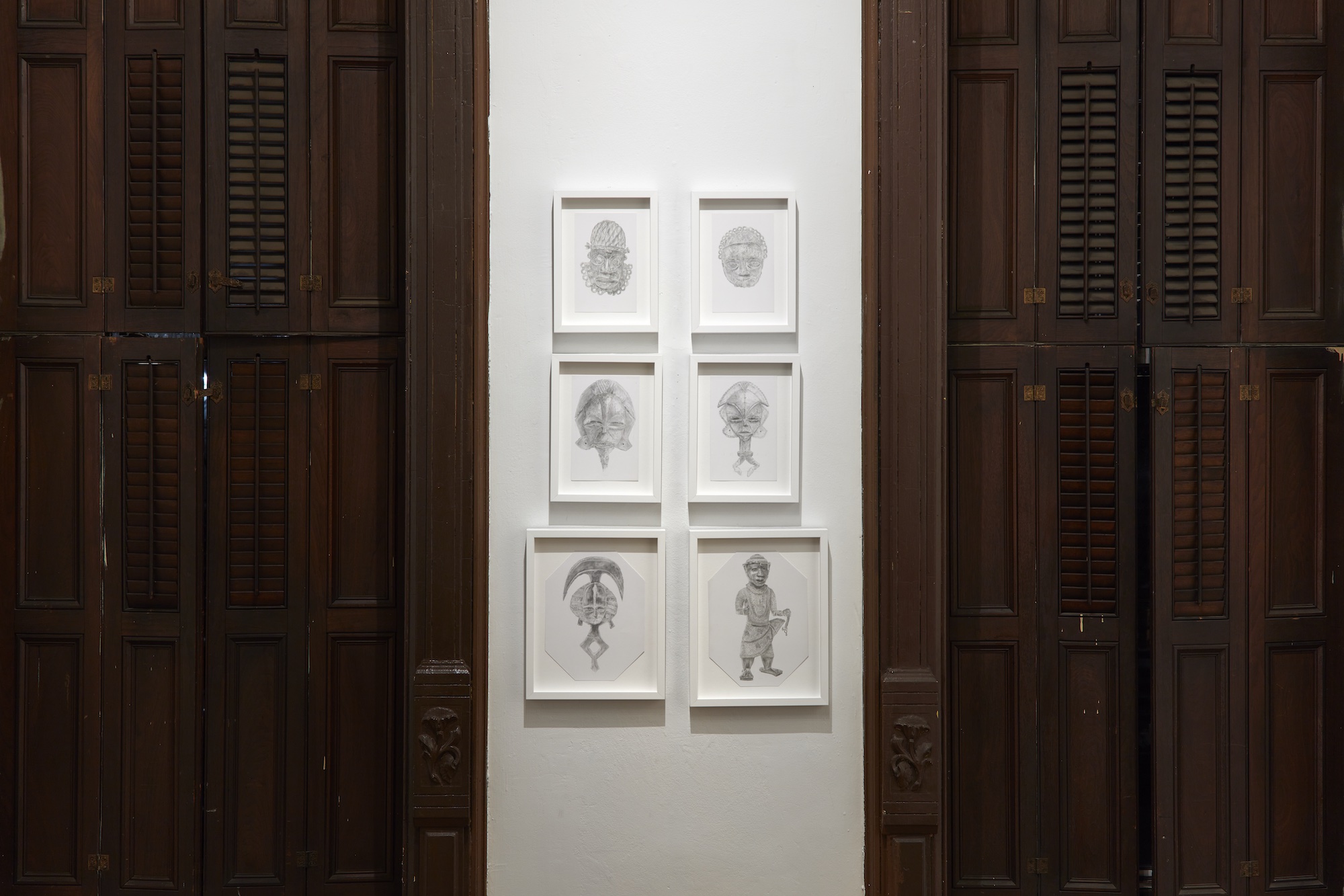 Image of drawings on the wall placed between two brown doors