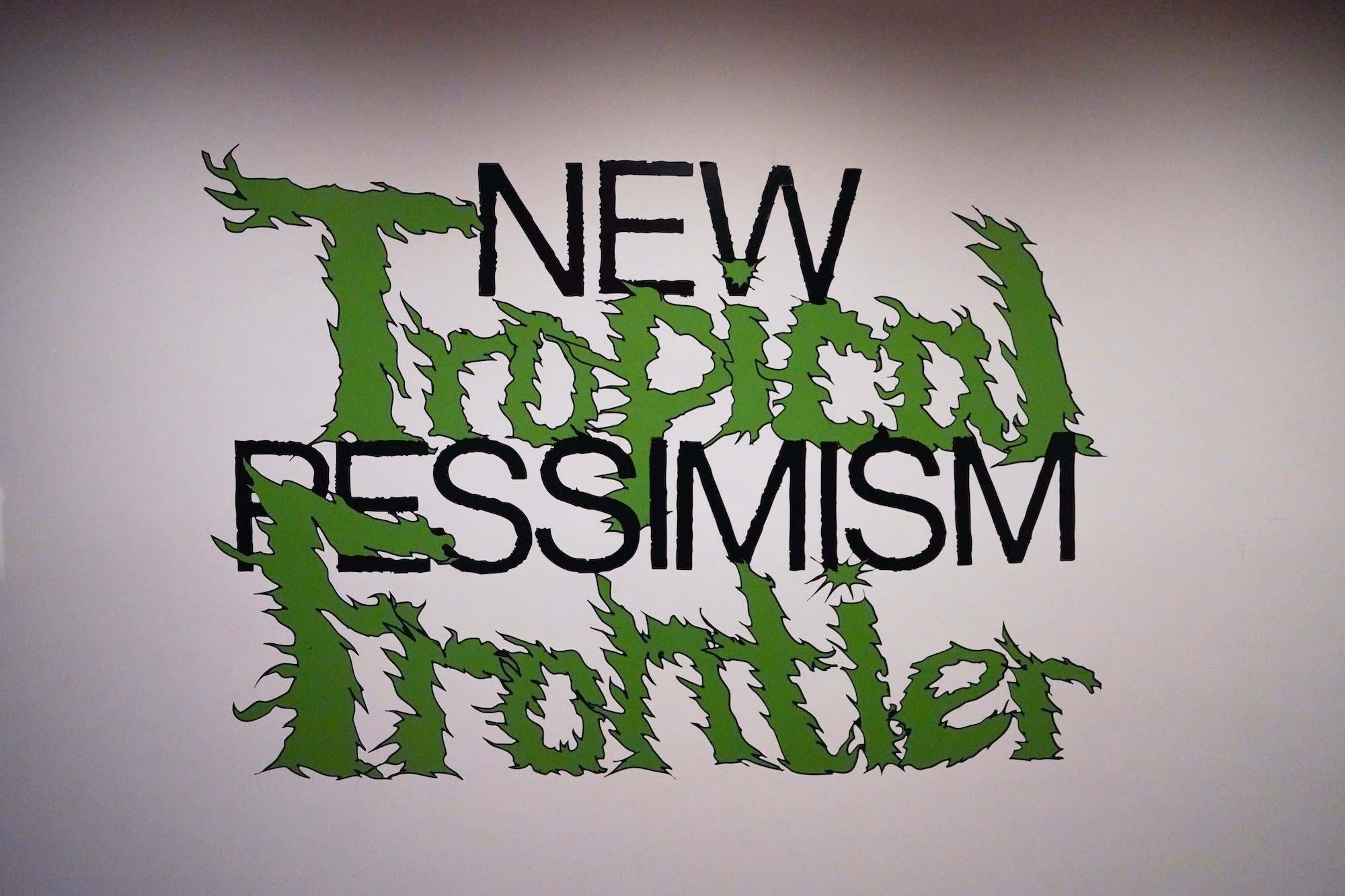 A title card reading New Pessimism Ropical Frontier in crazy green lettering.