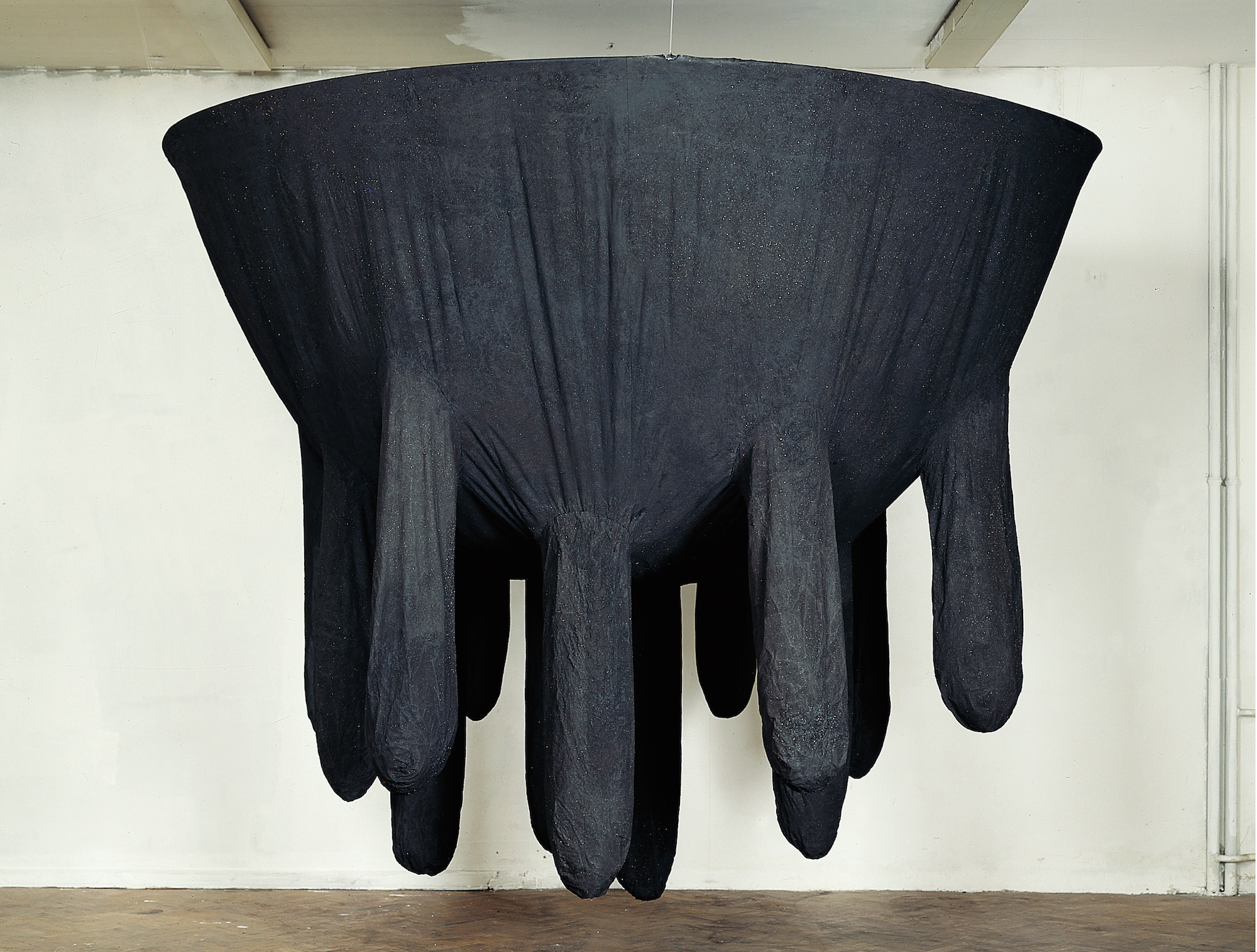 A large black udder made of what looks like a soft fabric hangs from the ceiling.